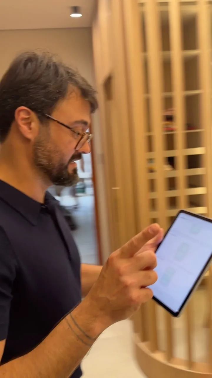 Kaká Pitombo conferindo o projeto em um tablet durante a obra